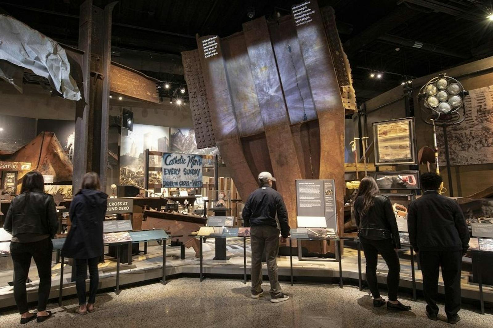 Vizitatori contemplând detriturile Memorialului & Muzeului 9/11